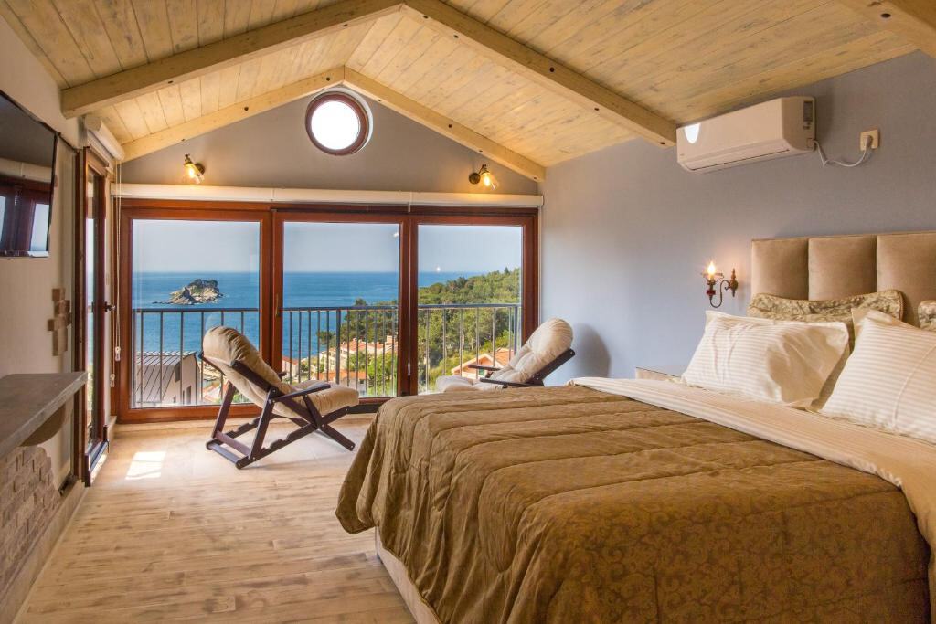 Apartment bedroom with sea view windows and wooden ceiling